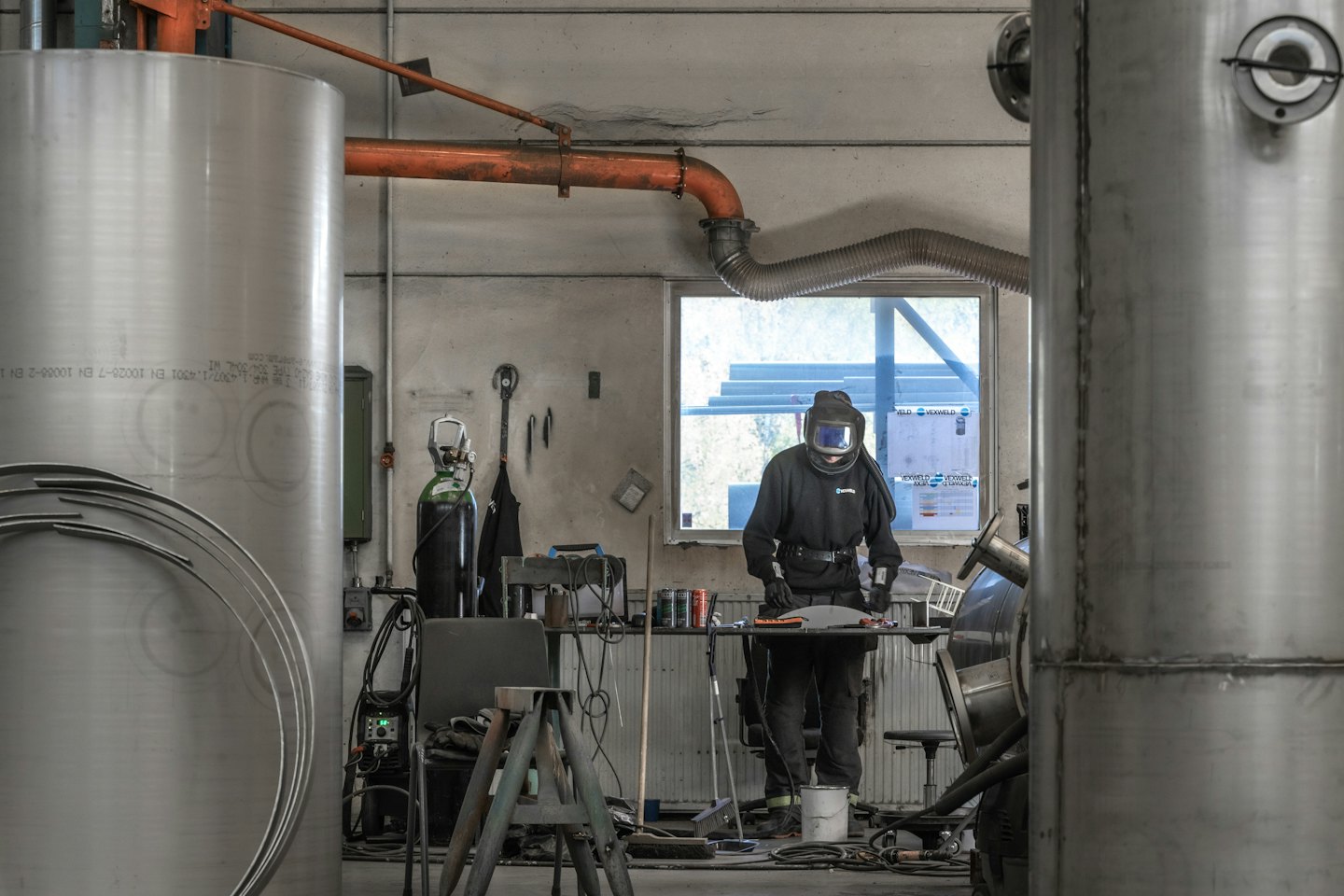 Welder fabricating metal parts in a workshop.