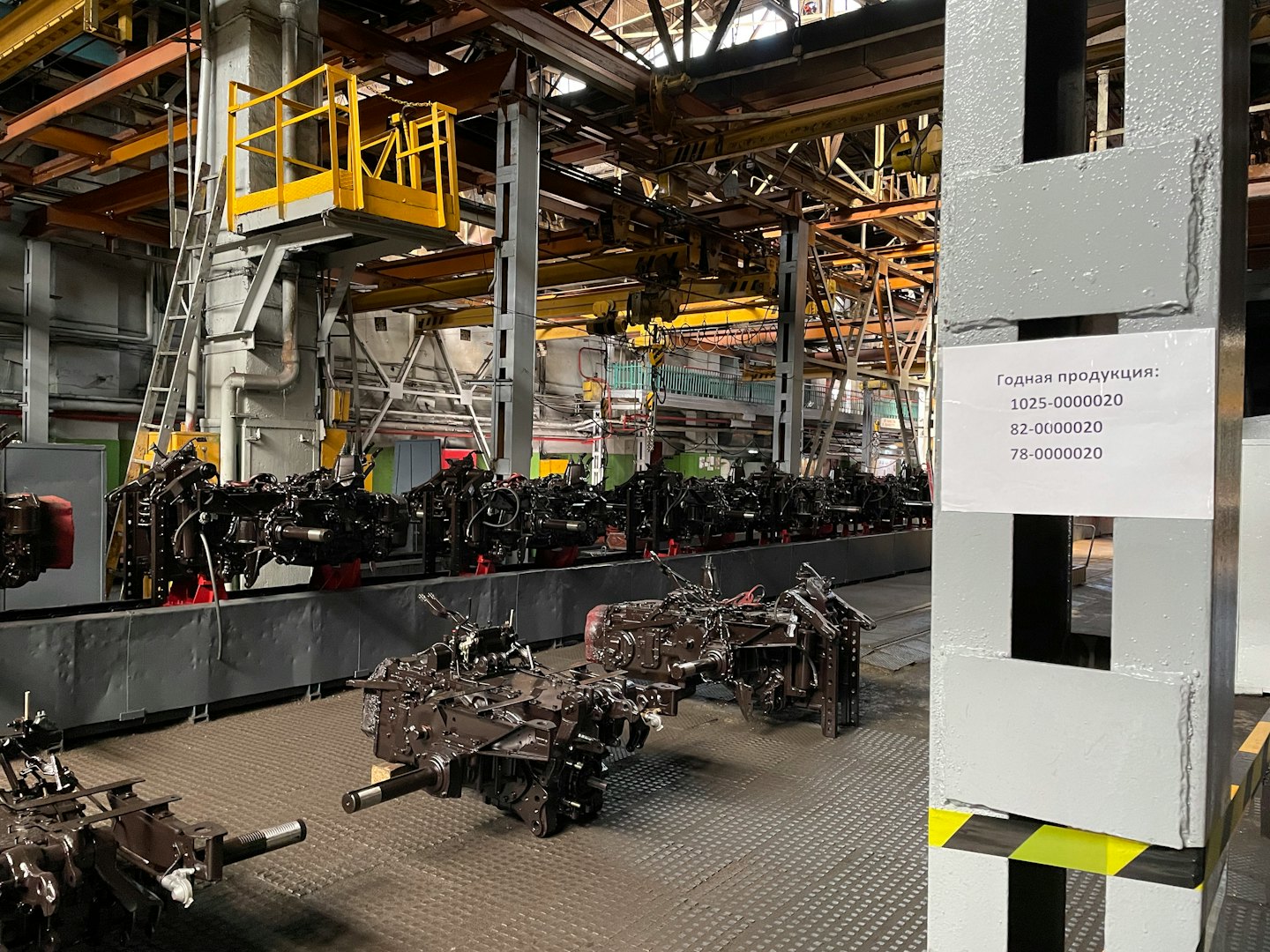 Heavy machinery components on a factory assembly line conveyor.