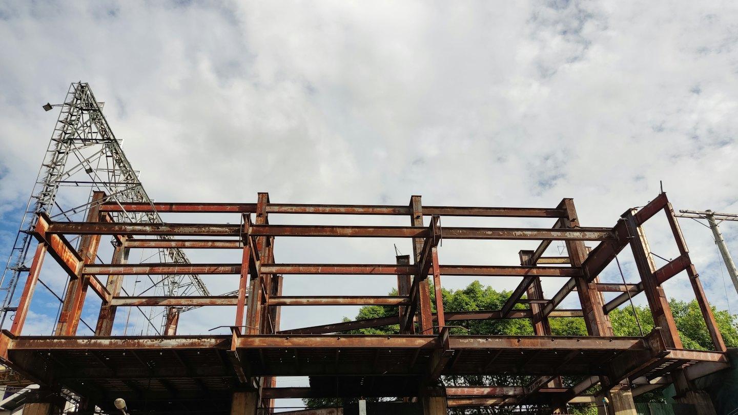 Steel girders form the skeletal structure of an unfinished building.